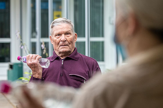 Käsijumppaa Jumppahetki pihalla, Naantalin Aurinkosäätiön asukas nostelee vesipulloja